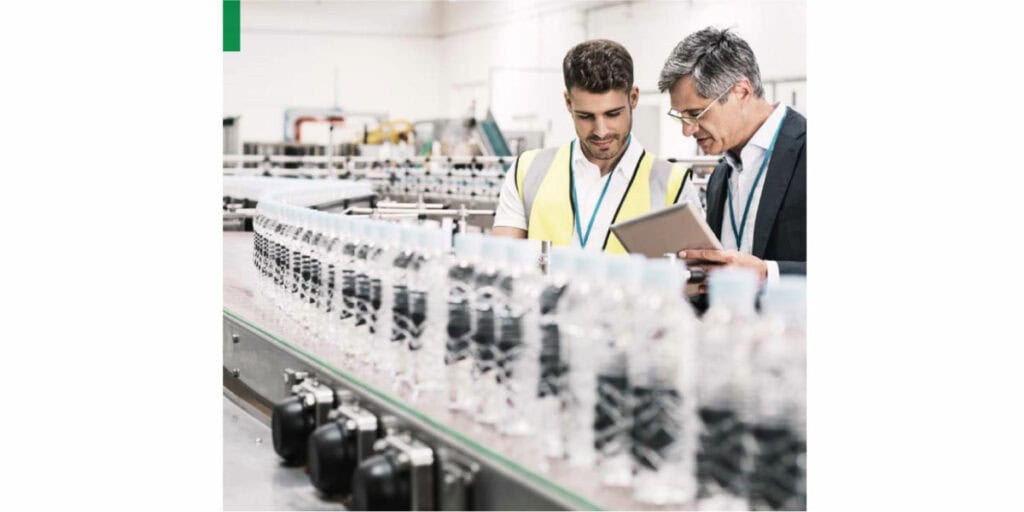 Two men working in a factory looking at a tablet.
